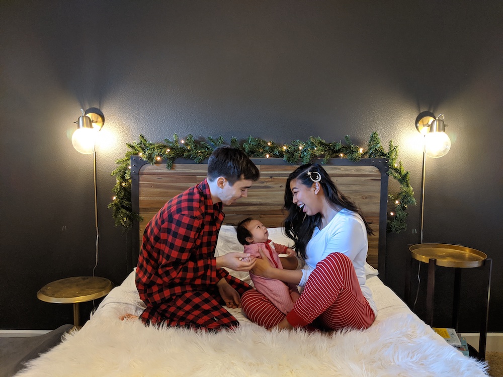 Dr. Ren & Dr. Christy with their child in a bedroom
